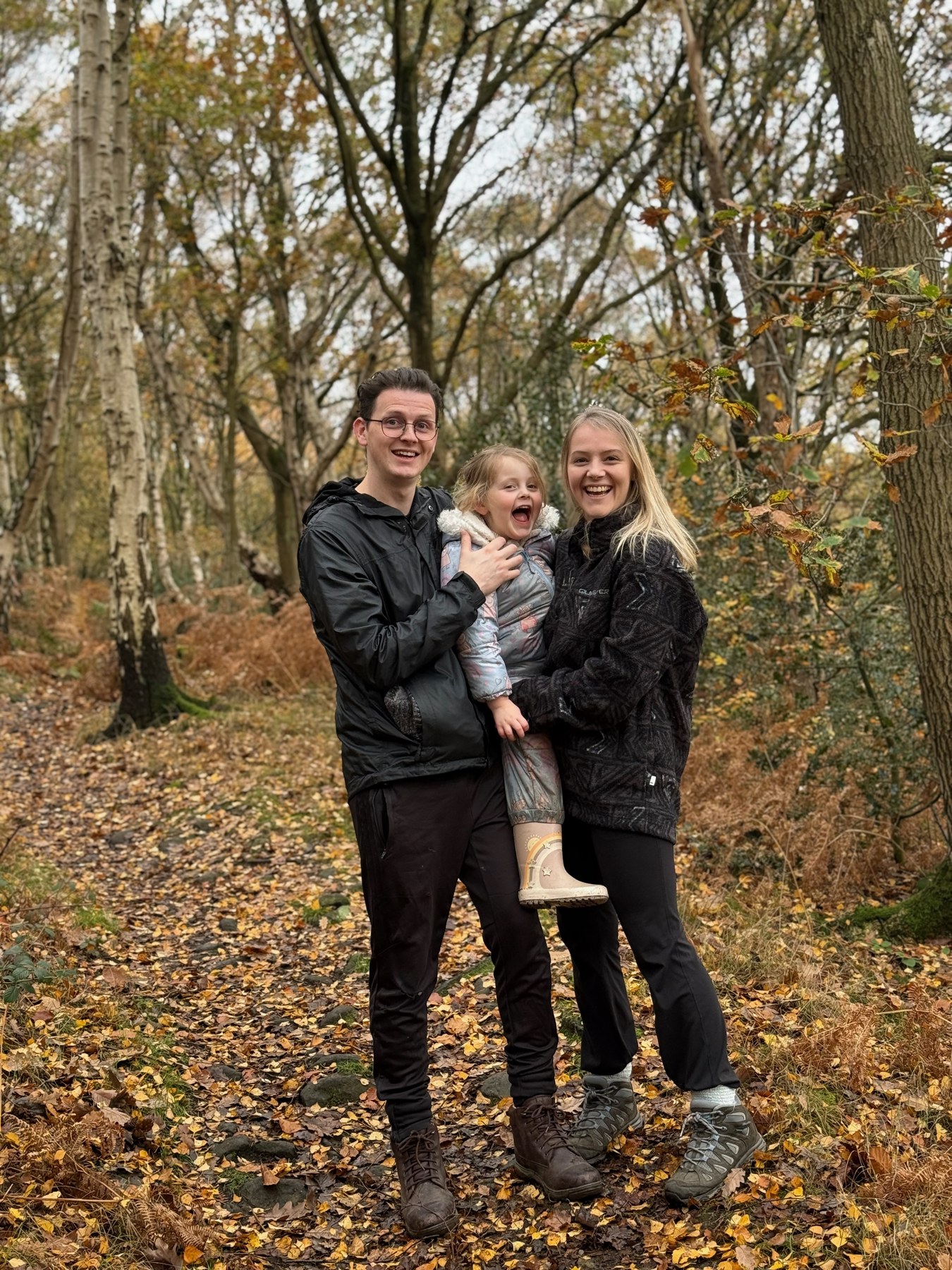 Nathan and Becca with their daughter on an autumn woodland walk